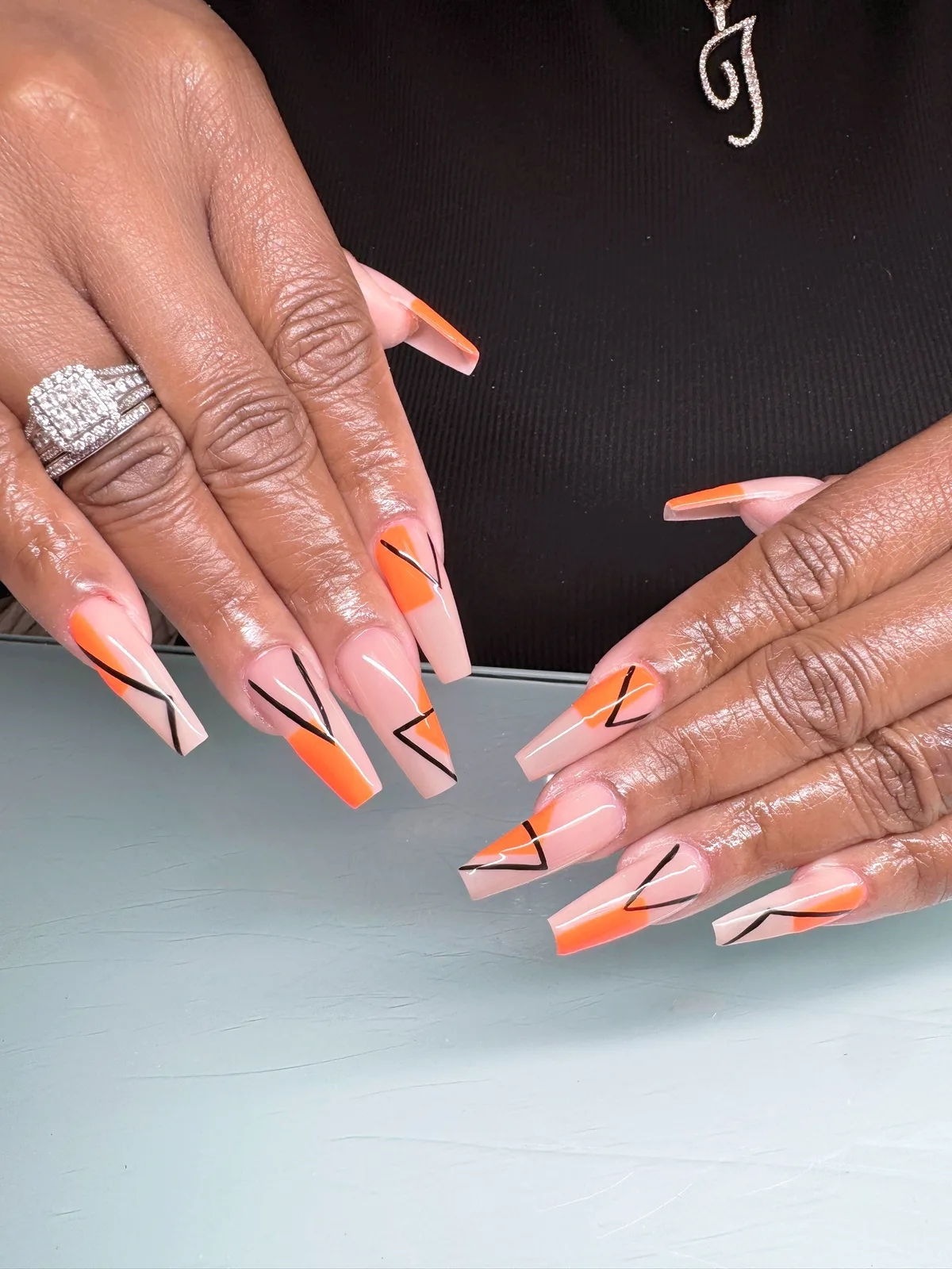Sculpted acrylic set with hand-drawn orange line art, done at Yary's Nails 2